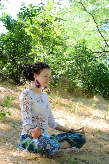 Young attractive woman meditate sitting in autumn forest