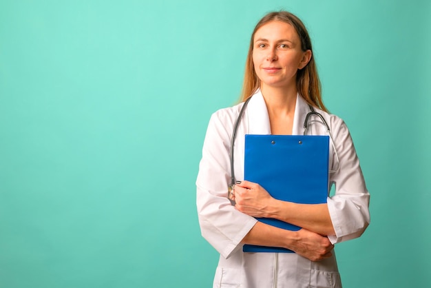 Young attractive woman nurse or doctor in a white coat with file on background