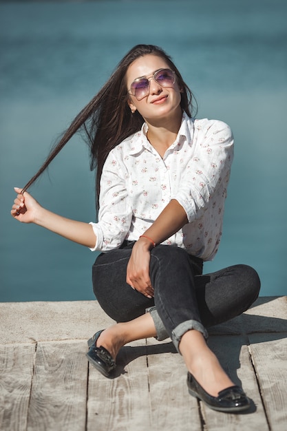 屋外の若い魅力的な女性。秋の時間に海で美しい女性