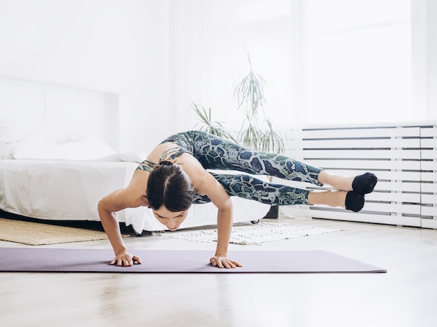 Yoga di pratica della giovane donna attraente. la femmina tiene il busto e le gambe in aria. pratica di esercizi di yoga.