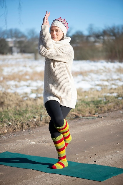 Foto giovane donna attraente che pratica lo yoga sulla strada rurale attività all'aperto pratica yoga asana