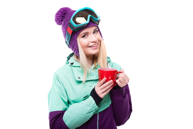 Young attractive woman in purple ski suit hold red cup