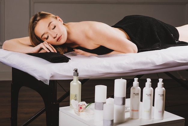 Young attractive woman relaxing on massage couch and ready for treatment