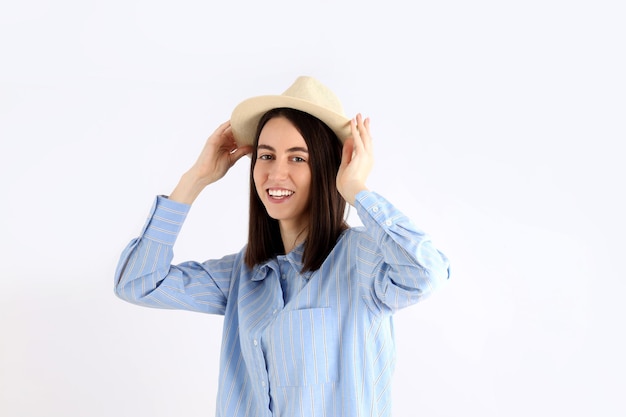 Young attractive woman in shirt and hat on white background