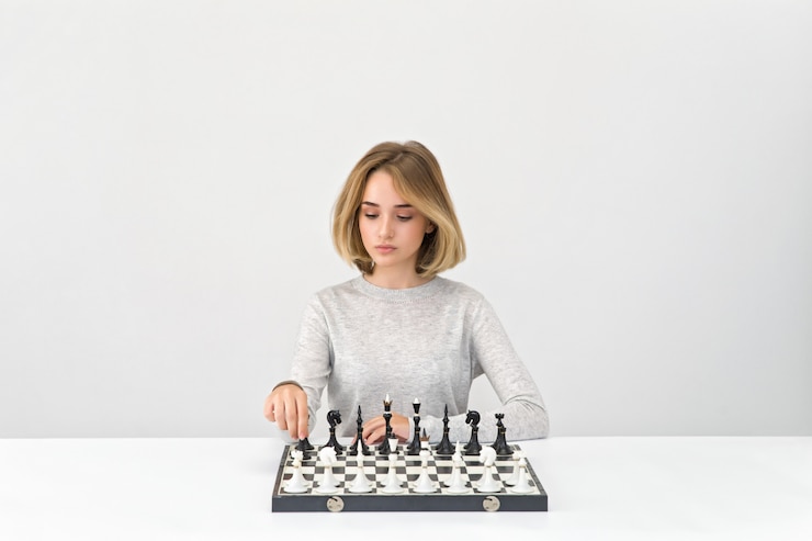 Photo young attractive woman sitting at table with a chessboard on it