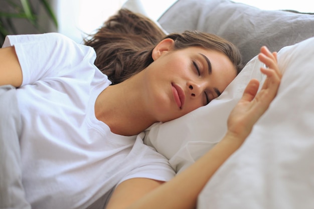 Young attractive woman sleeping in bed at home