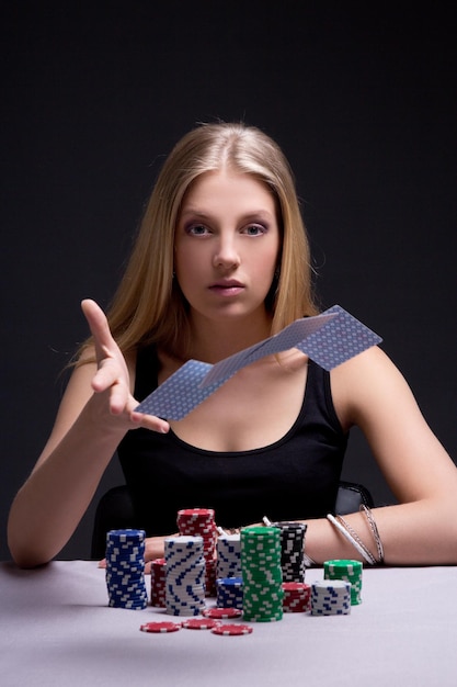 Young attractive woman throwing playing cards in casino