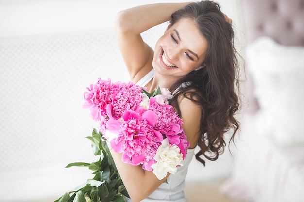花を持つ若い魅力的な女性