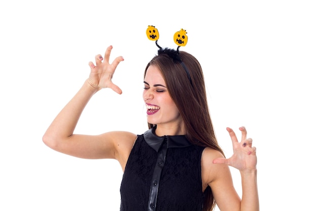 Young attractive woman with headband with pumpkins in dress laughing on white background in studio