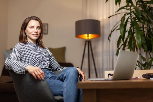 Young attractive woman with laptop on table in her home office