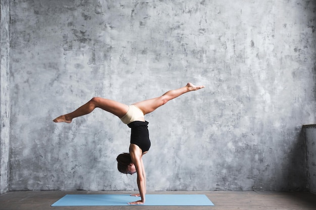 사진 adho mukha vrksasana 운동에 서 있는 요가 개념을 연습하는 젊은 매력적인 요기 여성은 아래쪽을 향한 나무 포즈 운동 전체 길이