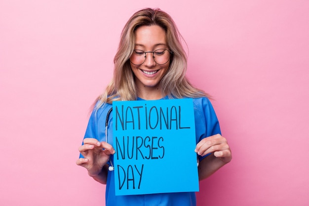 Young australian nurse woman holding a international nurses day placard isolated on blue background