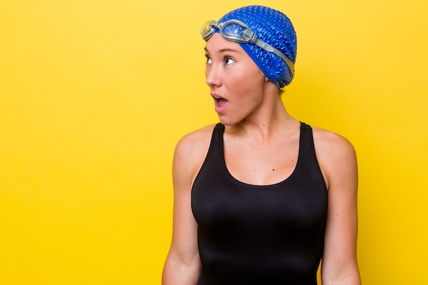 Young australian swimmer woman isolated on yellow background being shocked because of something she has seen