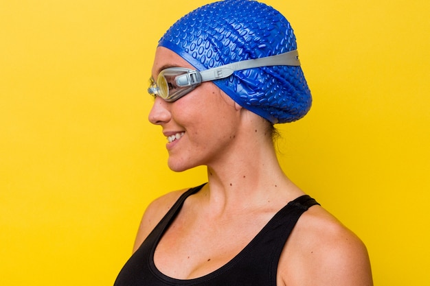 Young australian swimmer woman isolated on yellow background