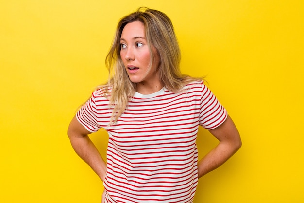 Young australian woman isolated looks aside smiling, cheerful and pleasant.