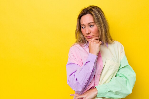 Young australian woman isolated touching back of head, thinking and making a choice.