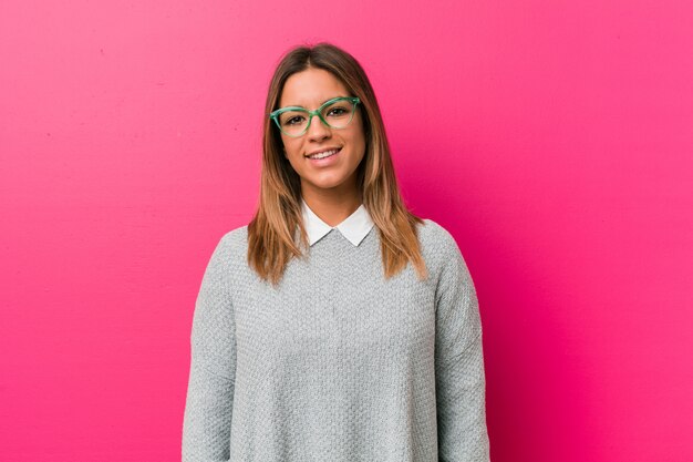 Young authentic charismatic real people woman against a wall happy, smiling and cheerful.