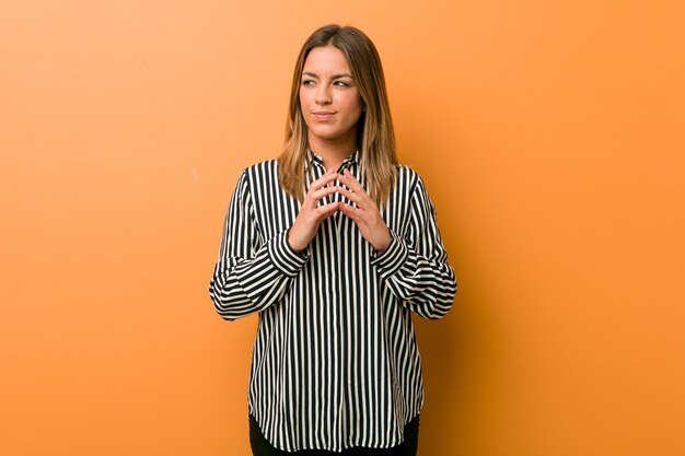 Young authentic charismatic real people woman against a wall making up plan in mind, setting up an idea.