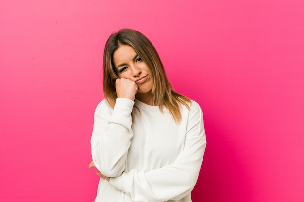 Young authentic charismatic real people woman against a wall who feels sad and pensive, looking at copy space.