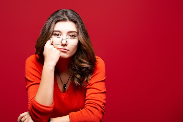 Young authentic charismatic woman against a red wall