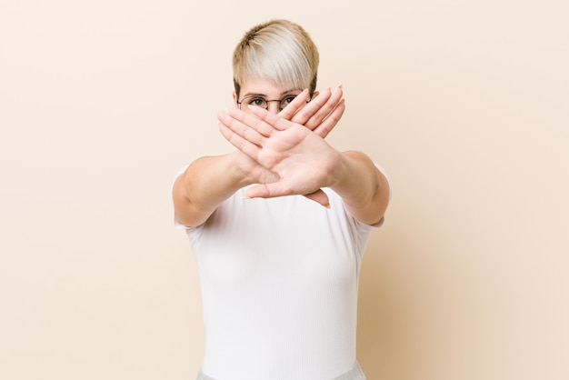 Young authentic natural woman wearing a white shirt doing a denial gesture