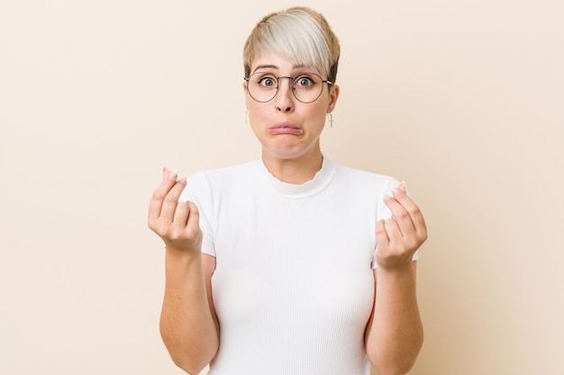 Giovane donna naturale autentica che indossa una camicia bianca che mostra che non ha soldi.