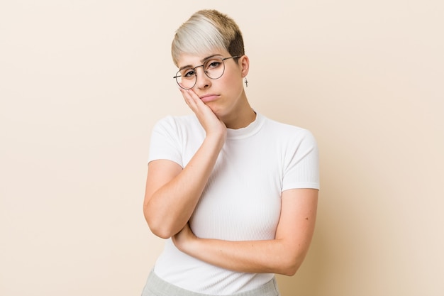 Young authentic natural woman wearing a white shirt who is bored, fatigued and need a relax day.