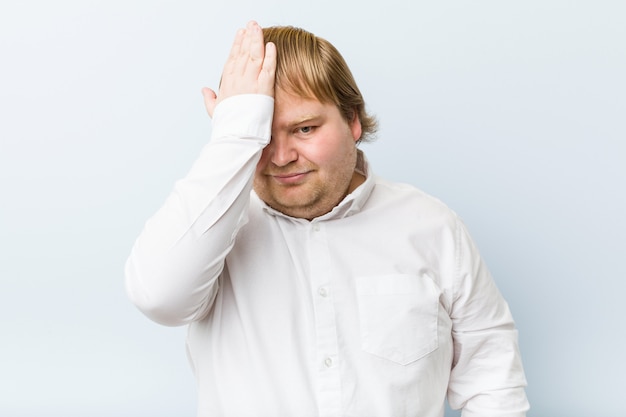 Young authentic redhead fat man forgetting something, slapping forehead with palm and closing eyes.