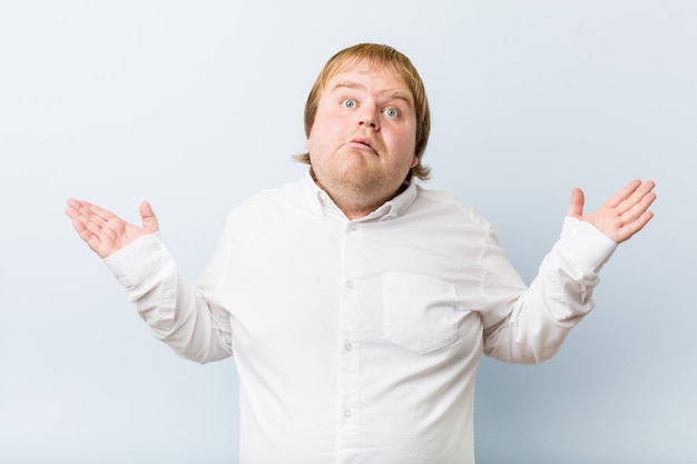 Photo young authentic redhead fat man surprised and shocked.