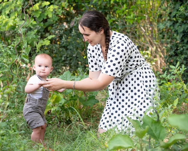 young baby and mother gardening in her kitchen garden