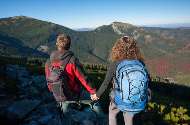 Foto i giovani viaggiatori con zaino e sacco a pelo si godono il bello paesaggio