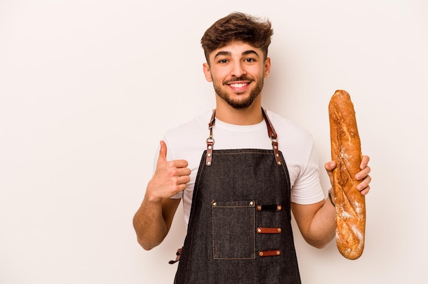 Young baker hispanic man isolated on white background smiling and raising thumb up