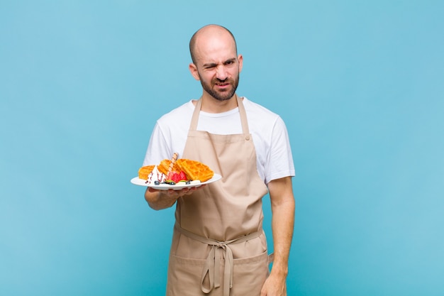 Young baker man with waffles