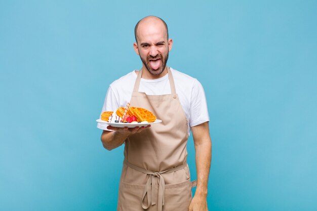 Young baker man with waffles