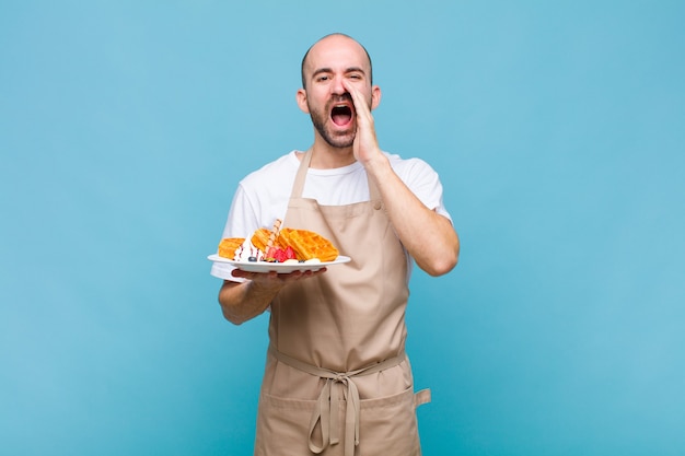 Young baker man with waffles