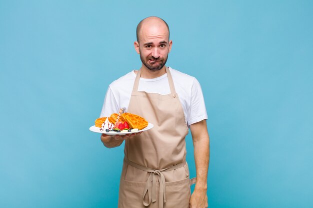 Young baker man with waffles