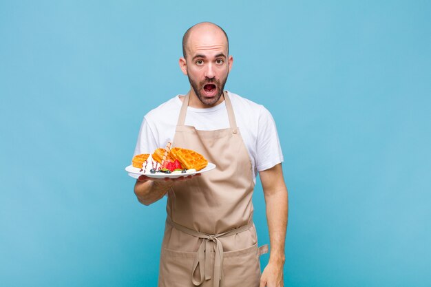 Young baker man with waffles