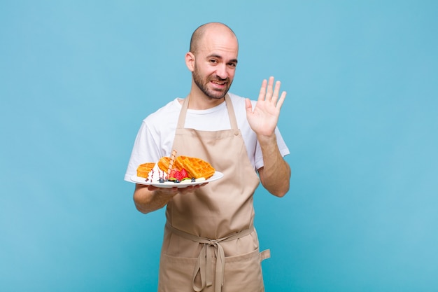 Young baker man with waffles