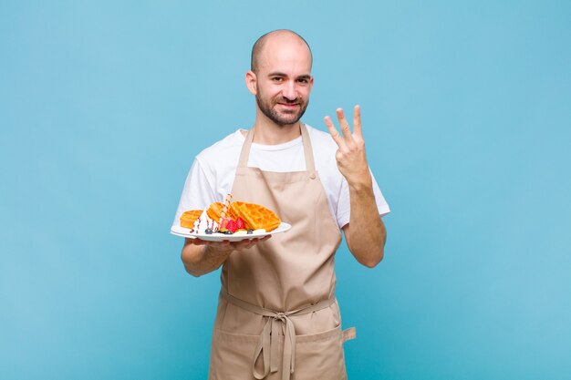 ワッフルを持つ若いパン屋の男