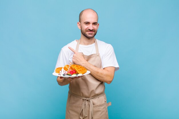 Young baker man with waffles