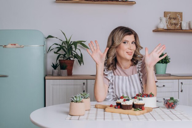 Young baker woman holding cupcakes