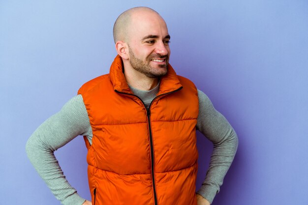 Young bald man isolated wall confident keeping hands on hips