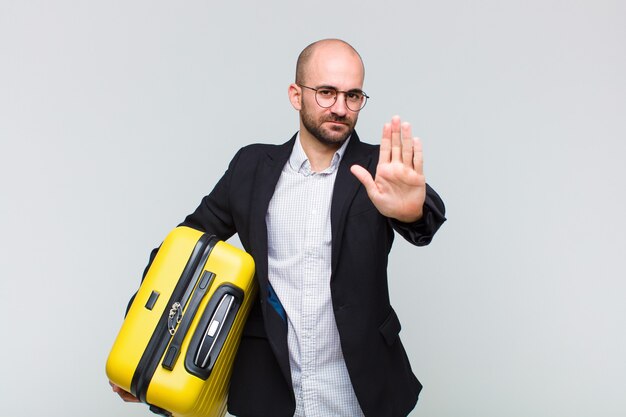 Young bald man making stop gesture