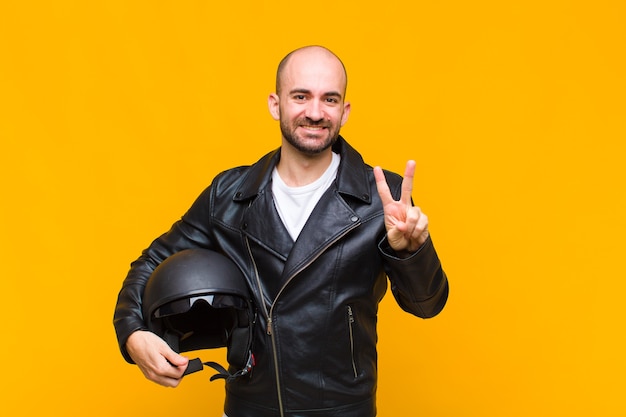 Young bald man smiling and looking happy