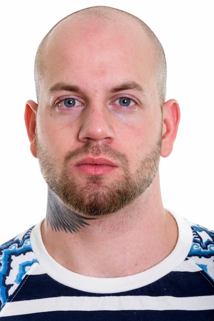 Young bald muscular man isolated against white wall