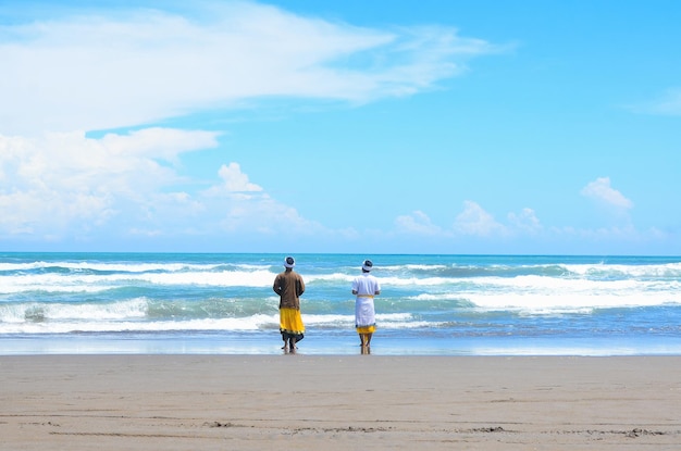 Young Balinese Praying on the Beach in Parangkusumo Yogyakarta with Traditional Balinese Dress