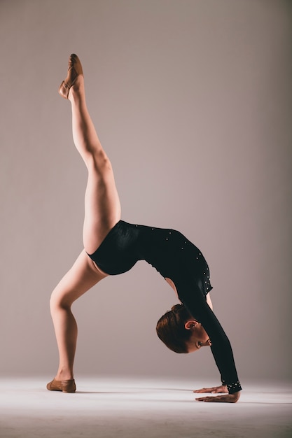 Young ballerina having exercises in the studio