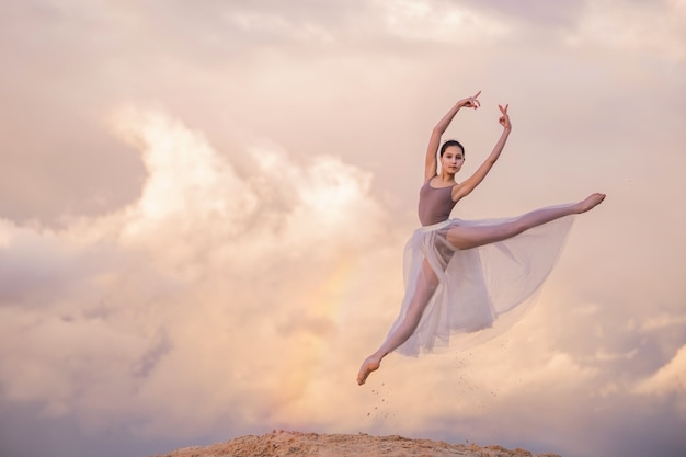 Фото Молодая балерина в длинном платье танцует