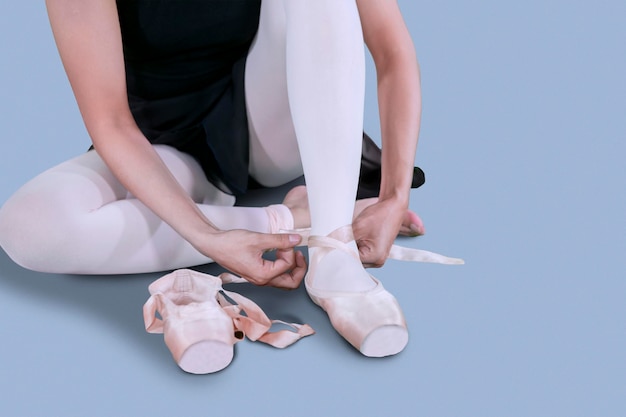 Photo young ballet dancer tying her shoes