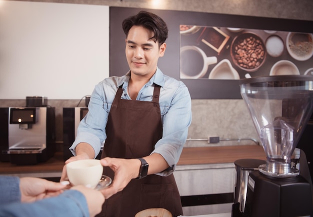 Young barista with the intention of making up a latte coffee to satisfy customers both in appearance